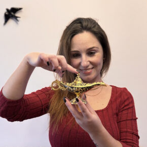 Mulher segura uma lâmpada mágica dourada e sorri