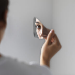 Pessoa a segurar um pequeno espelho que reflete o seu olhar